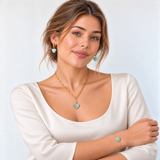 Model in schlichter elfenbeinfarbener Bluse mit rundem Ausschnitt und Amazonit-Herzschmuck in Mintgrün und Hellblau.