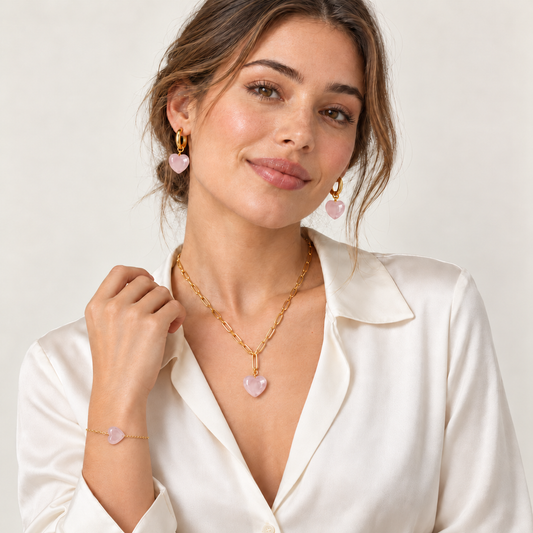 Model mit goldfarbener Halskette, Creolen und Armband mit Herzen aus Rosenquarz.
