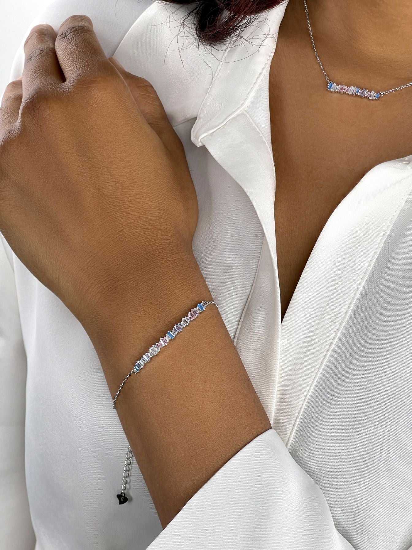 Livia Armband aus der Kollektion Cool Shine mit pastellfarbenen Zirkonia am Handgelenk eines Models.