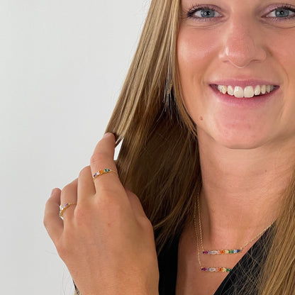 Nahaufnahme eines Models mit dem Color 22 Shine Ring aus vergoldetem Edelstahl und bunten rechteckigen Zirkonia-Steinen.