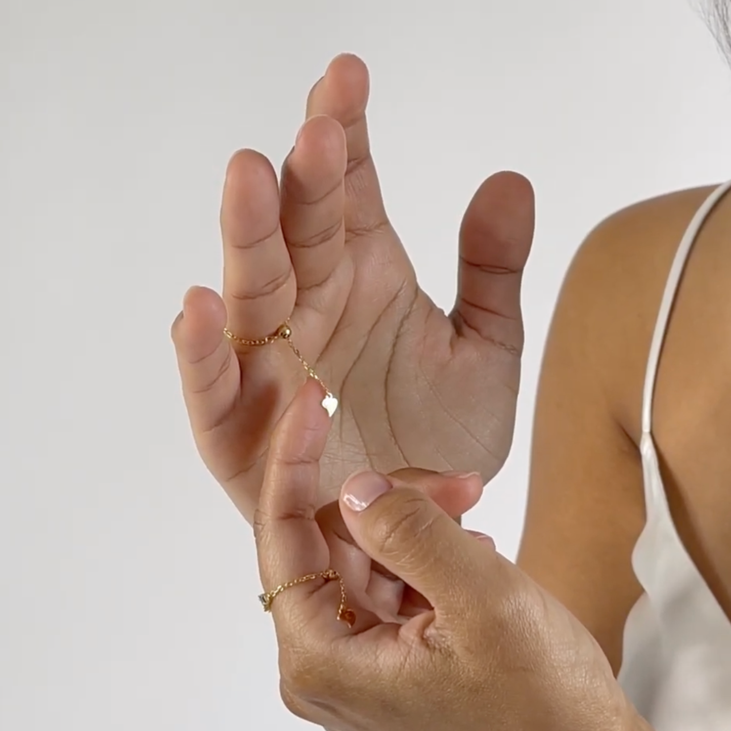 Detailaufnahme des Color 22 Shine Rings an der Hand eines Models mit bunten rechteckigen Zirkonia-Steinen.