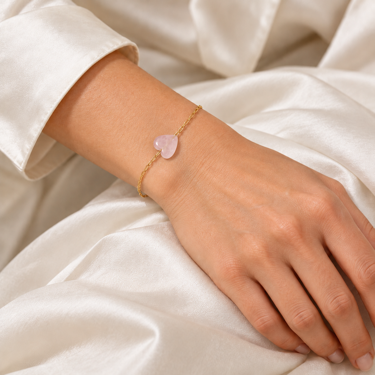 Harmony Touch Armband mit feiner goldfarbener Kette und Rosenquarz-Herz am Handgelenk.