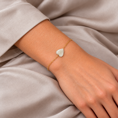 Harmony Touch Armband mit feiner goldfarbener Kette und cremeweissem Mondstein-Herz am Handgelenk.